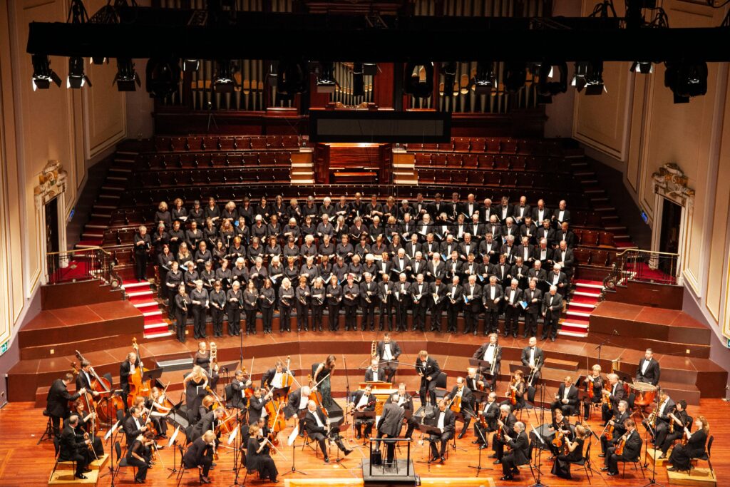 A majestic orchestra and choir performing at a historic venue in Edinburgh, Scotland.
